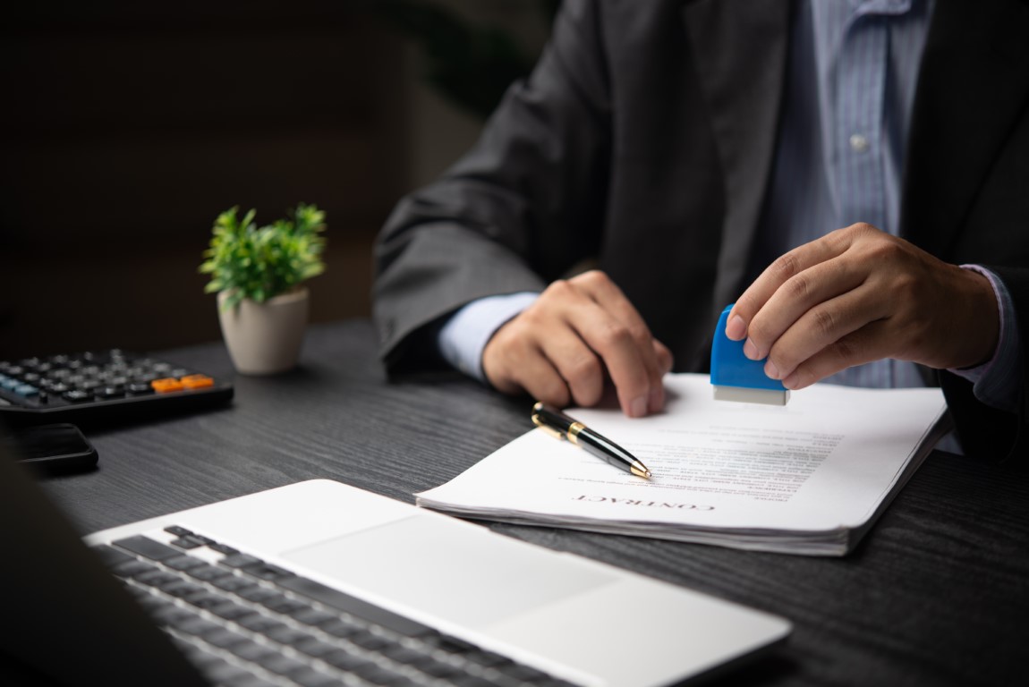 Businessman,Applying,A,Stamp,To,Approve,A,Legal,Contract,,Symbolizing